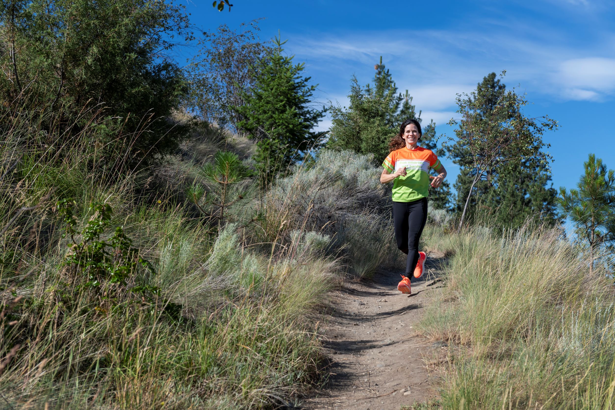 Smiling woman running on trail
